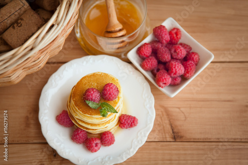 Pancakes with raspberry on wooden table