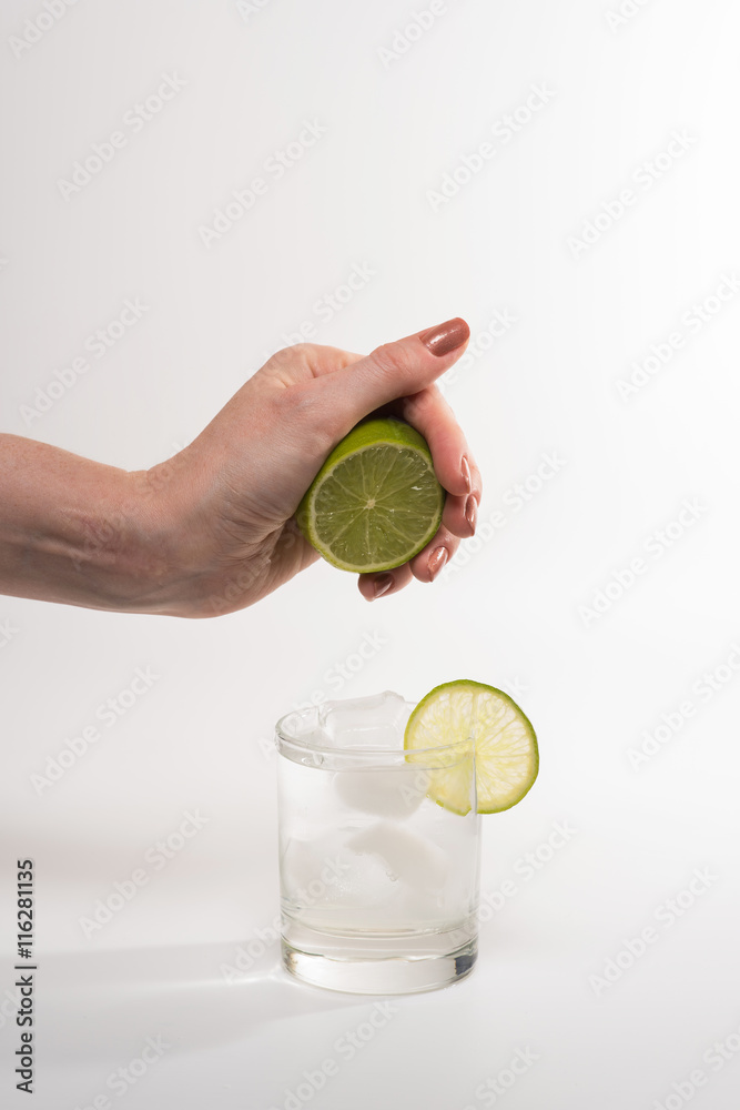 Fototapeta premium Female hand squeezing lime