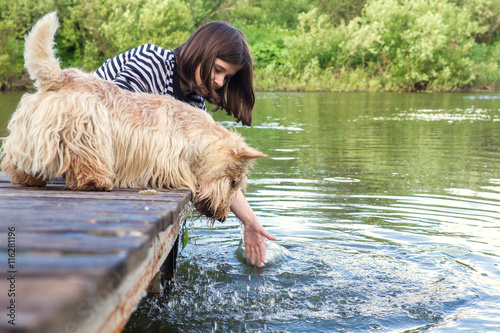 Teen Girl and Scottish Terrier dog on the bridge near the water