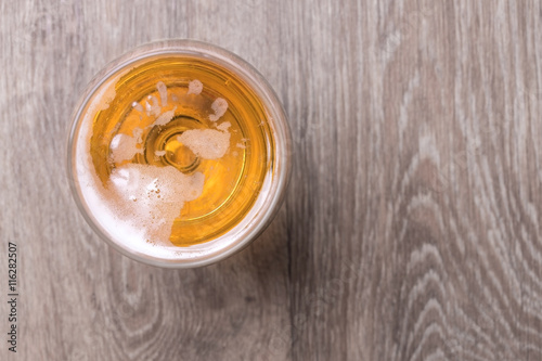 Glass of beer on wooden background.