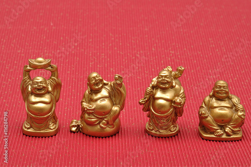 Row of Figurines of laughing and cheerful golden Buddhas