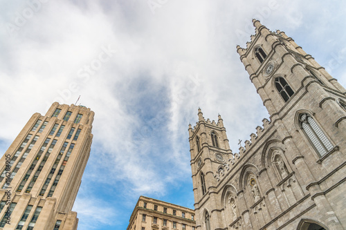 Low angle view of Aldred Building and Notre-Dame Basilica of Montreal photo