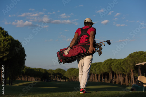 golfer walking and carrying golf bag
