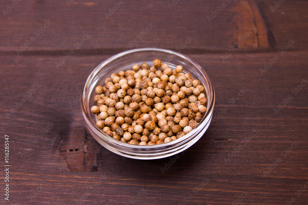 Coriander seeds on a bowl on a wooden table Coriander seeds on a bowl on a wooden table