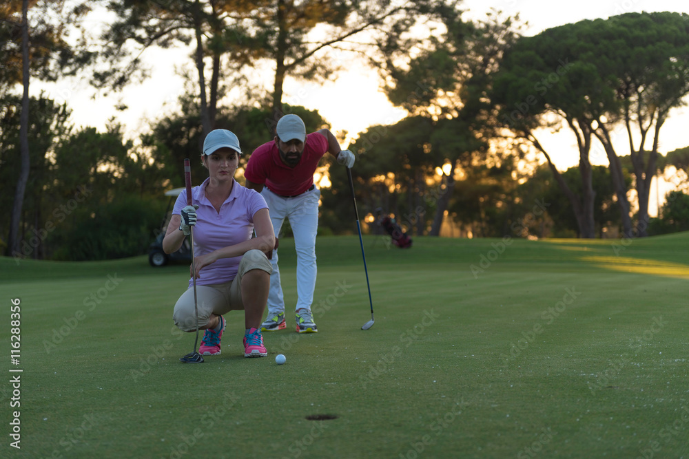 Obraz premium couple on golf course at sunset