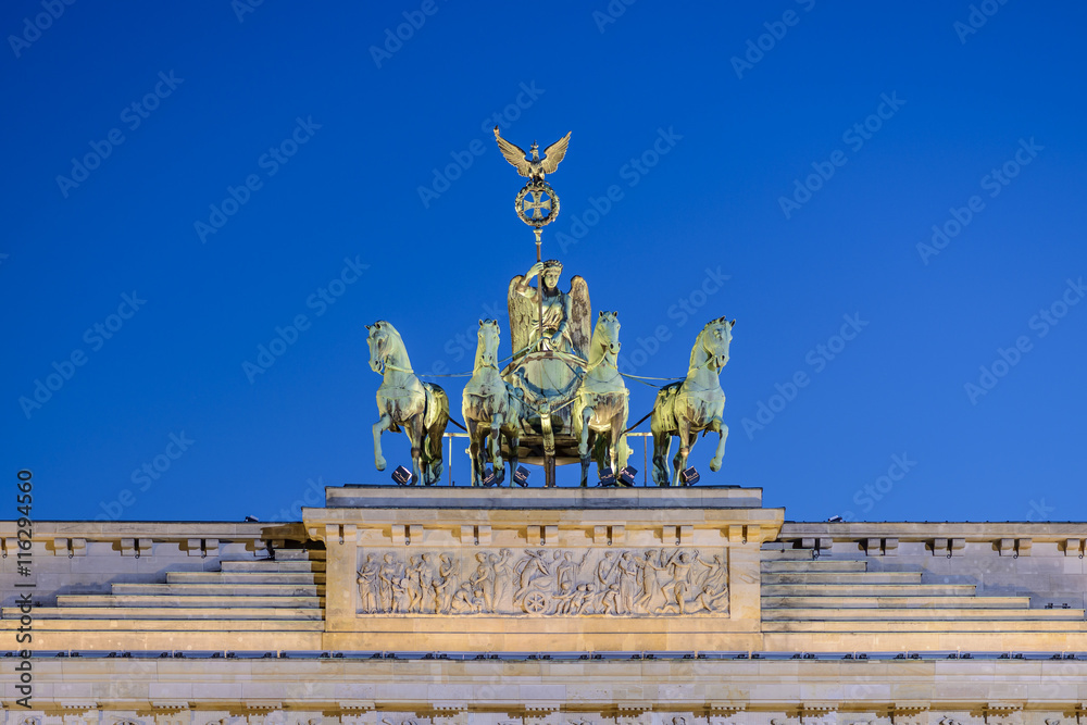 Obraz premium the illuminated bronze sculpture Quadriga on the Brandenburg Gate (Brandenburger Tor) in the evening, Berlin, Germany, Europe