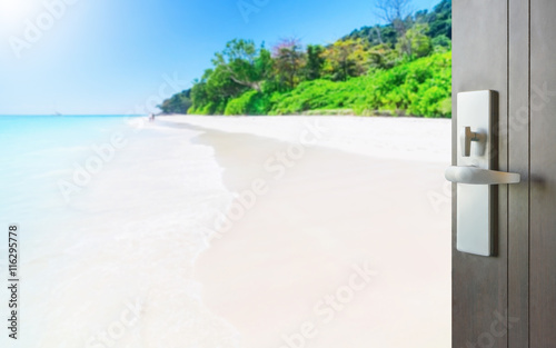 opened wooden door to beautiful tropical beach under clear sky in summer