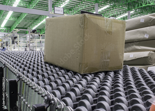 Cardboard boxes on conveyor belt in distribution warehouse