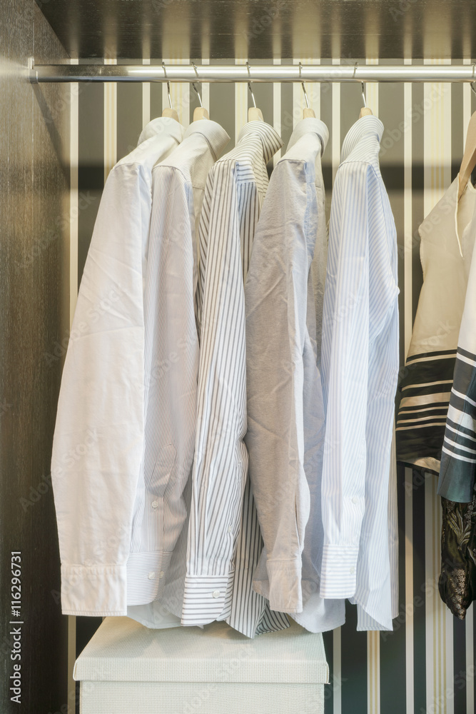 Row of white shirts hanging in retro style background wardrobe