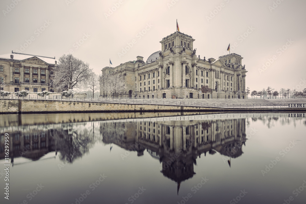 Reichstag building (Bundestag) and with reflection in river Spree in Winter, Berlin government district, Germany, Europe, Vintage filtered style