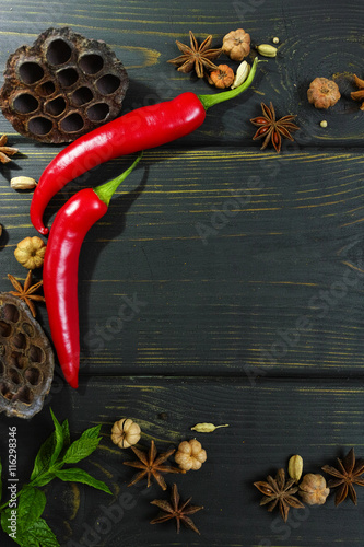 Colorful red hot chili peppers on black wooden table top