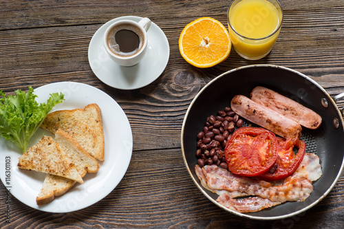 Full English breakfast with sausage, baked tomato, beans and toa
