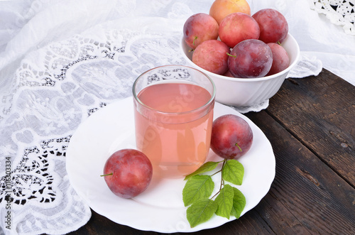 juice of red plums , the white bowl on wooden table