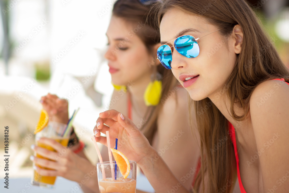 two attractive young women drinking cocktails two attractive young women drinking cocktails
