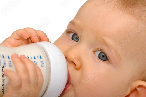 Baby trinkt selbständig aus Milchflasche photo