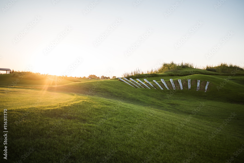 Beautiful golf course with collar rays of sun at sunset
