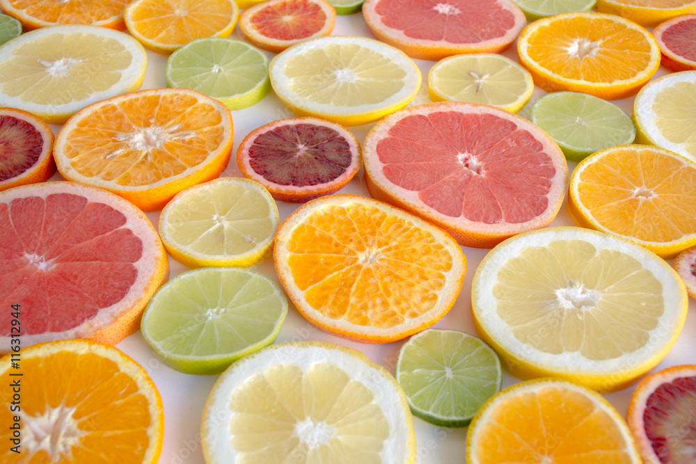Slices of orange, grapefruit, blood orange lemon, lime arranged as a background Slices of orange, grapefruit, blood orange lemon, lime arranged as a background