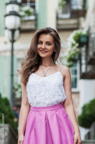 Outdoor portrait of young beautiful fashionable happy smiling lady walking at street of the old city. City lifestyle © voloshin311