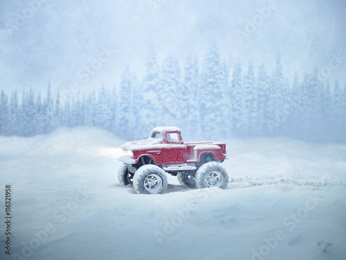 Miniature red monster truck in winter storm