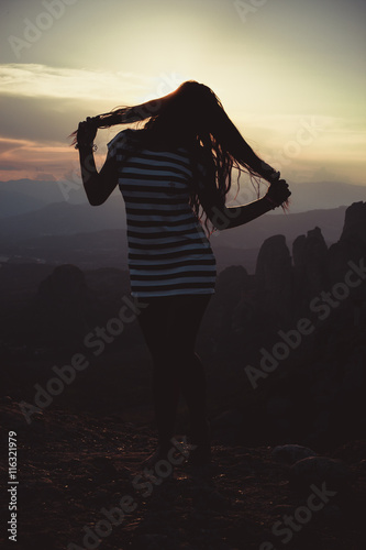 silhouette of a lonely girl at sunset in Meteora, Greece