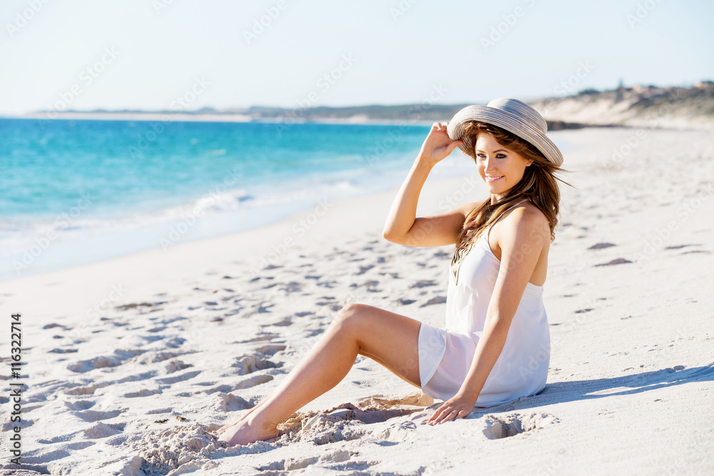 Young woman sitting on the beach