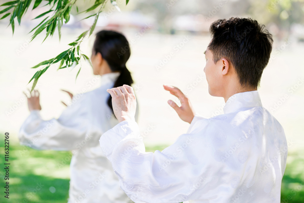 People practicing thai chi in park People practicing thai chi in park