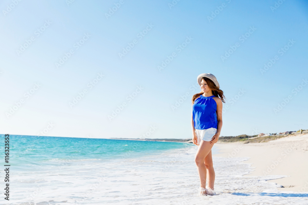 Young woman walking along the beach