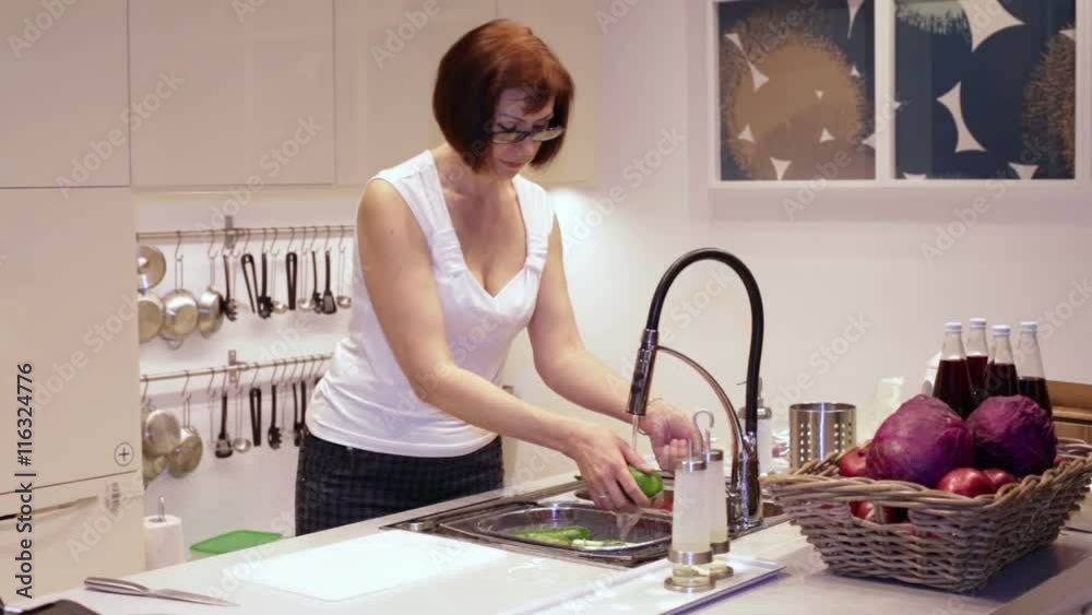 Woman Washing Vegetables in the Kitchen Woman Washing Vegetables in the Kitchen