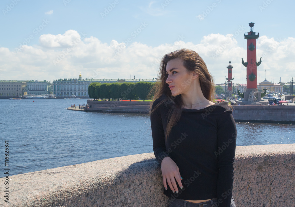 beautiful girl tourist posing on the background of the Hermitage and Strelka of Vasilyevsky island
