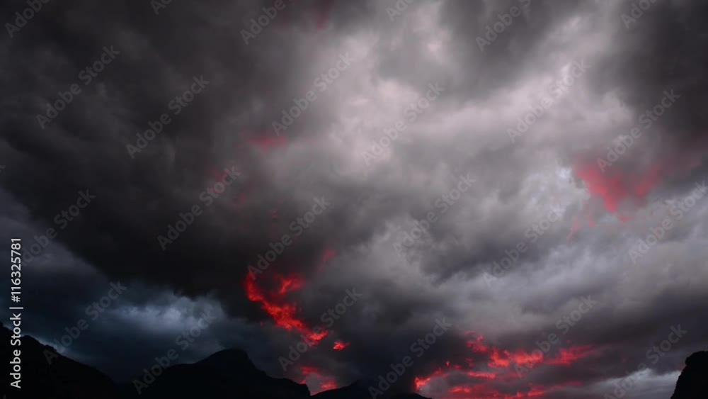 Storm, red clouds move across the sky. Tops of the mountains.