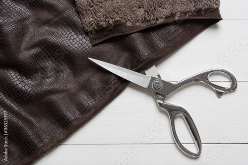 Photography Cutting dublin leather with tailor scissors on white table close