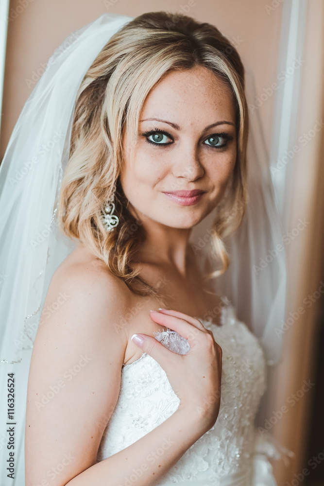 bride on the morning of the wedding day. Bride preparation. Earring. Blond bride. beautiful blond stylish bride getting ready in the morning in the room bride on the morning of the wedding day. Bride preparation. Earring. Blond bride. beautiful blond stylish bride getting ready in the morning in the room