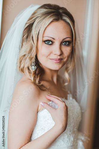 bride on the morning of the wedding day. Bride preparation. Earring. Blond bride. beautiful blond stylish bride getting ready in the morning in the room