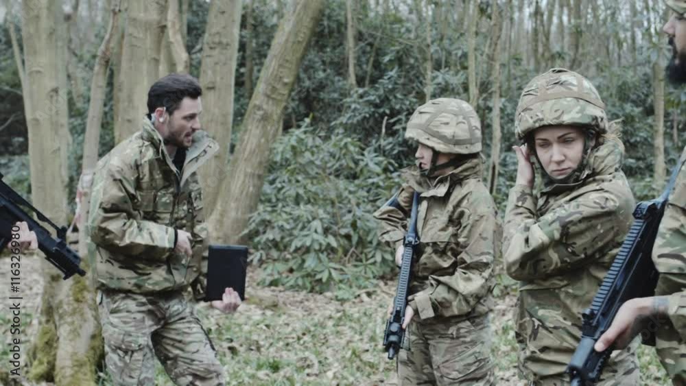 Army soldier giving instructions to team on training Army soldier giving instructions to team on training