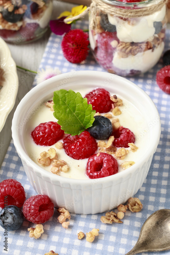 Breakfast table: bowl of yogurt with muesli and fresh fruits Breakfast table: bowl of yogurt with muesli and fresh fruits