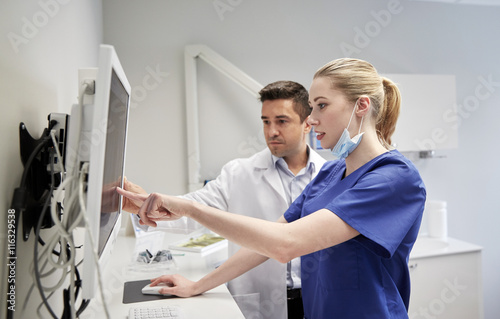 dentists with x-ray on monitor at dental clinic