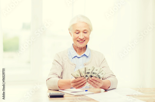 senior woman with money and papers at home