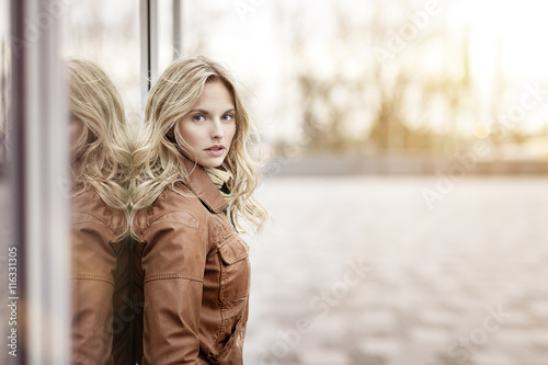 Young woman leaning on glass front photo