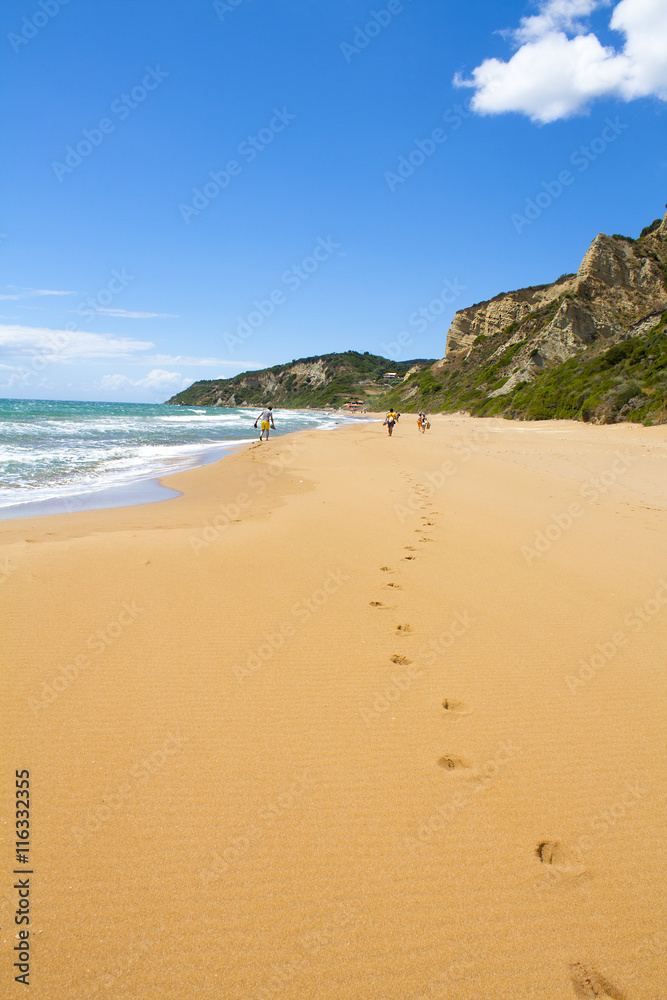 Amazing beach, waves and footsteps at summer time in Corfu island, Greece Amazing beach, waves and footsteps at summer time in Corfu island, Greece