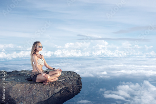 Woman meditating on a cliff