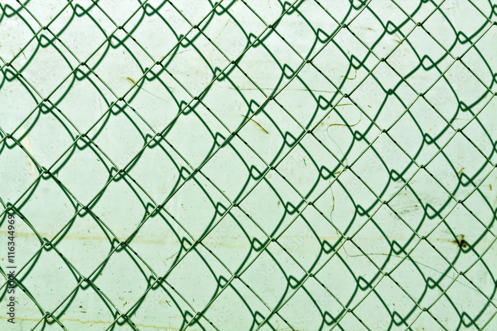 Fototapeta premium abstract chain link fence texture against grungy color wall.