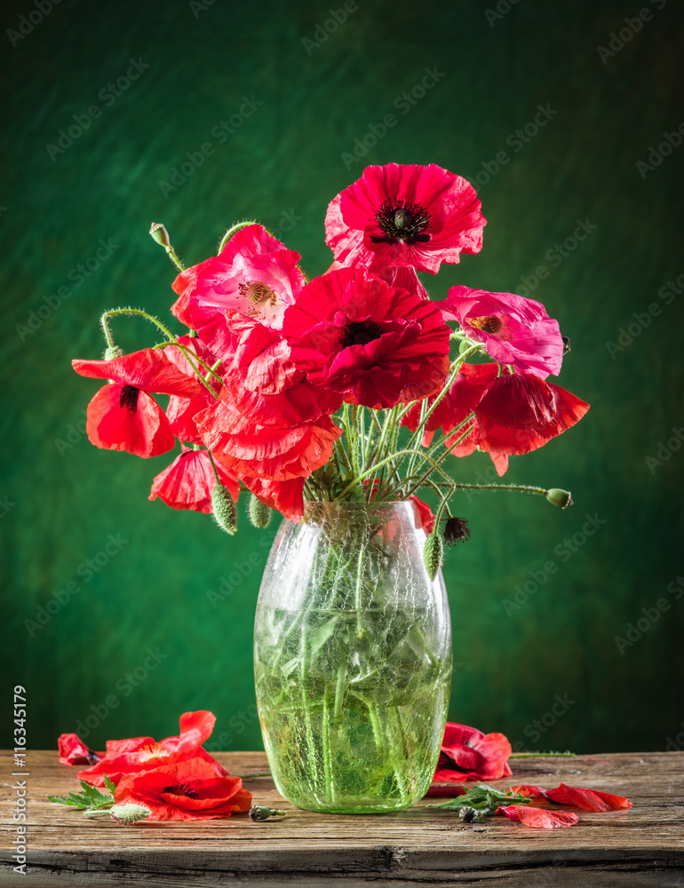 Fototapeta premium Bouquet of poppy flowers in the vase on the wooden table.