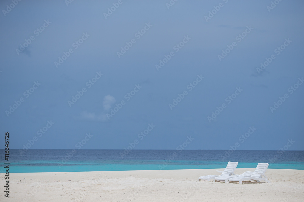 three beach chairs on the white beach