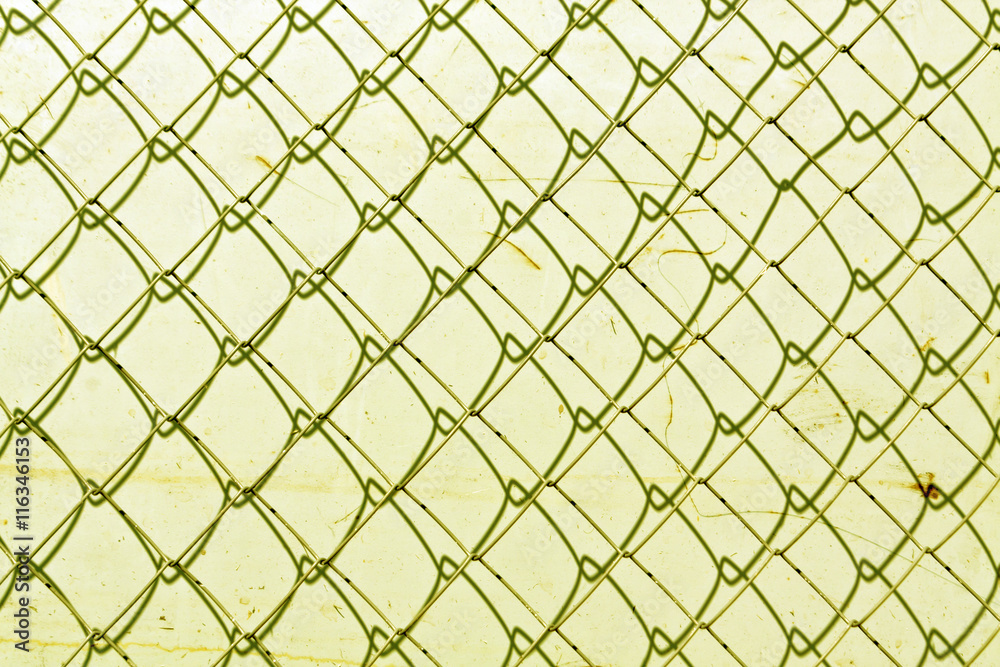 Fototapeta premium abstract chain link fence texture against grungy color wall.