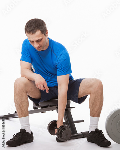 Young man doing exercises with dumbbells