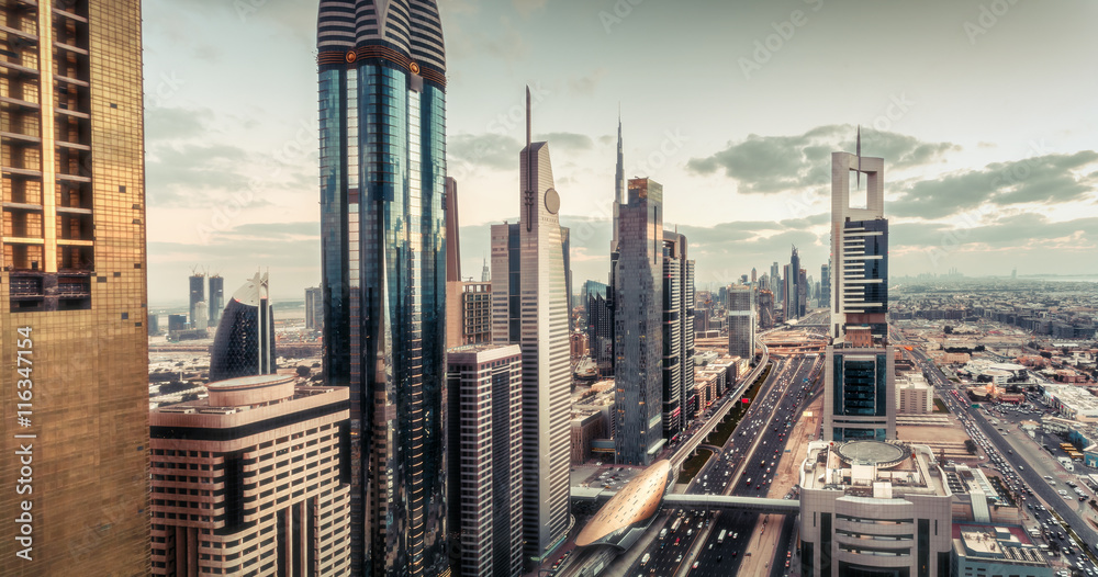 Fototapeta premium Aerial view over Dubai's famous architecture with highway and skyscrapers. Fantastic skyline.