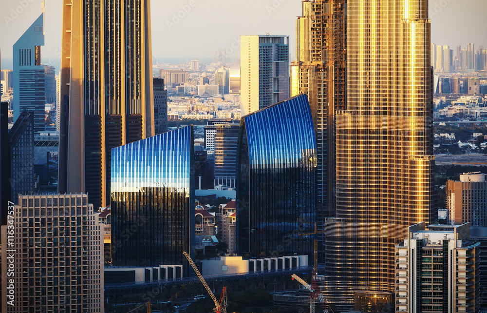 Fototapeta premium Beautiful architectural background. Close-up view of Dubai towers at sunset. Film effect.