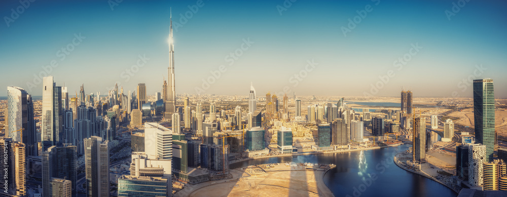 Naklejka premium Scenic panoramic view of Dubai modern architecture at sunset. Aerial daytime cityscape with downtown skyscrapers.