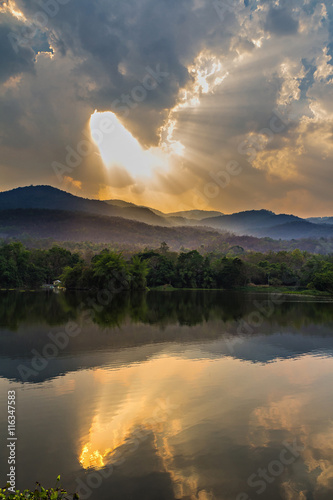 Clouds and sunbeam over mountain and lake