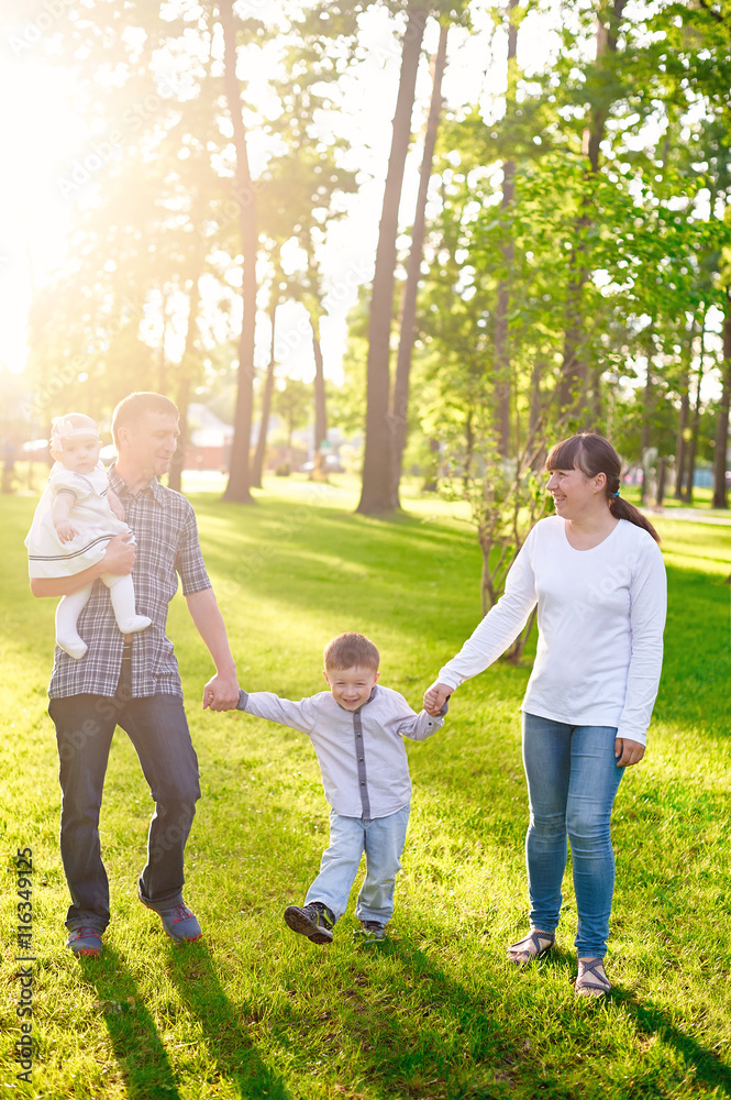 Fototapeta premium Happy young family with children walks in the summer park